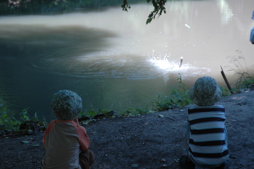 A fiúk nézik, amint egy kis  társuk épp kifog egy pisztrángot.